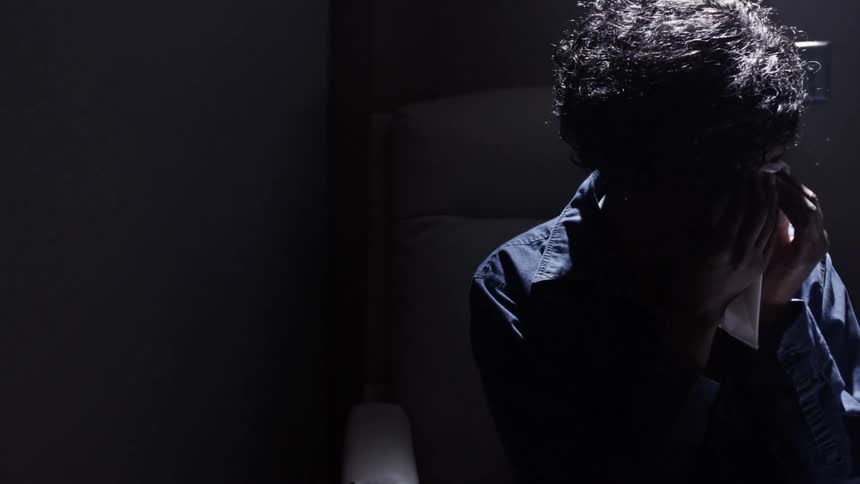 A person sitting in a shadow