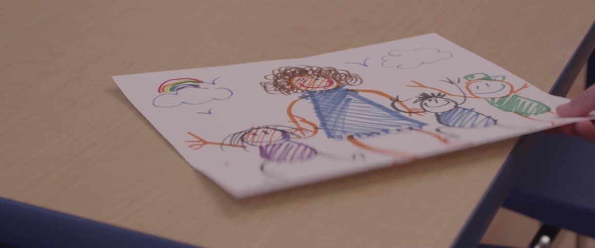 A drawing is lifted from the classroom desk