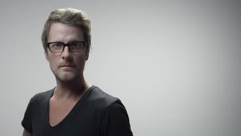 Man wearing glasses turns towards camera
