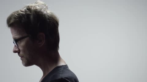 Man standing and looking down and slowly looking up