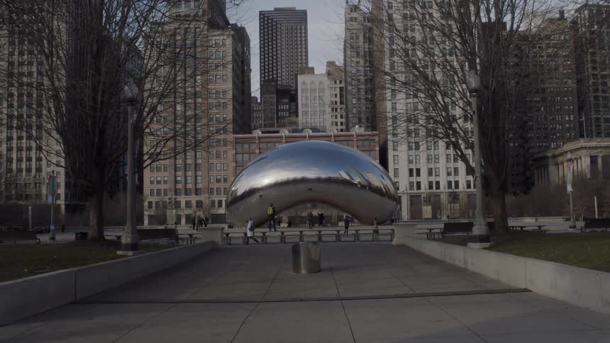 A man stands in front of a sculpture