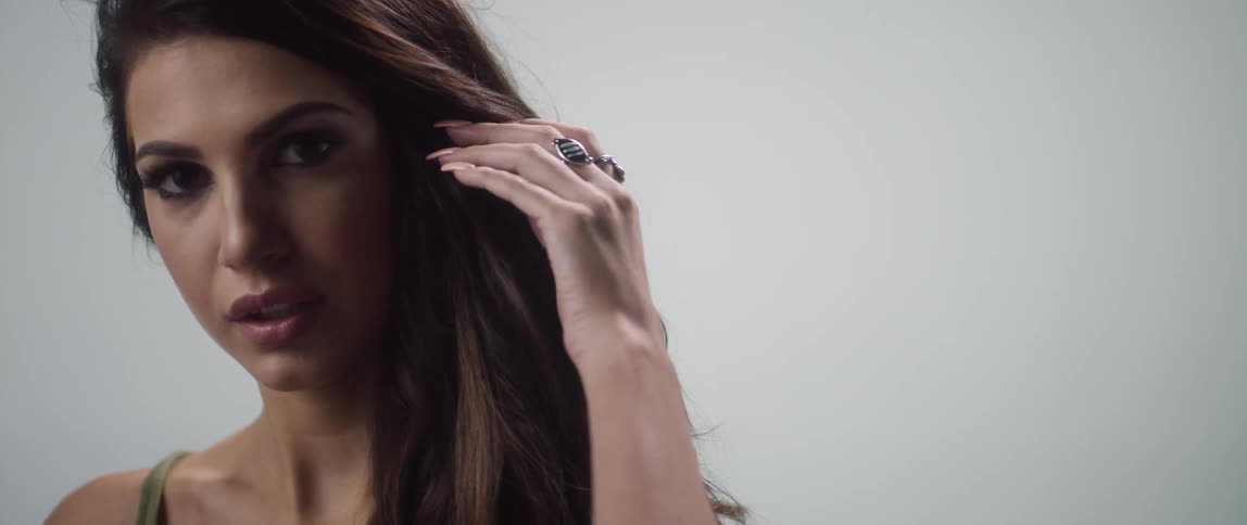 Woman turns her head then puts her hand through her hair