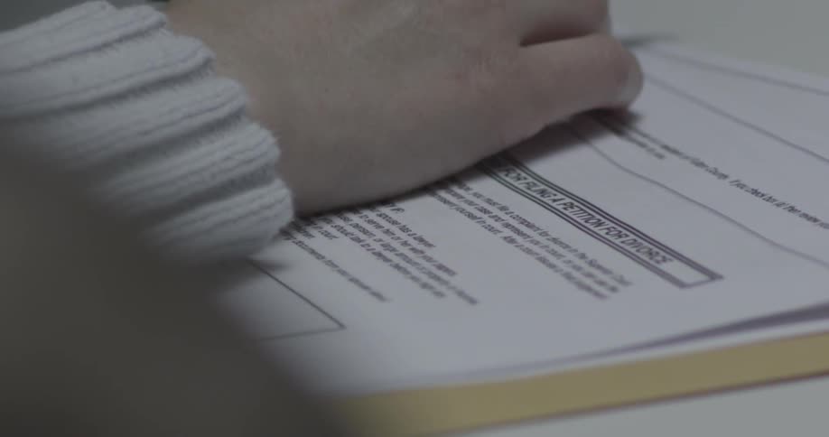 A hand on top of divorce papers