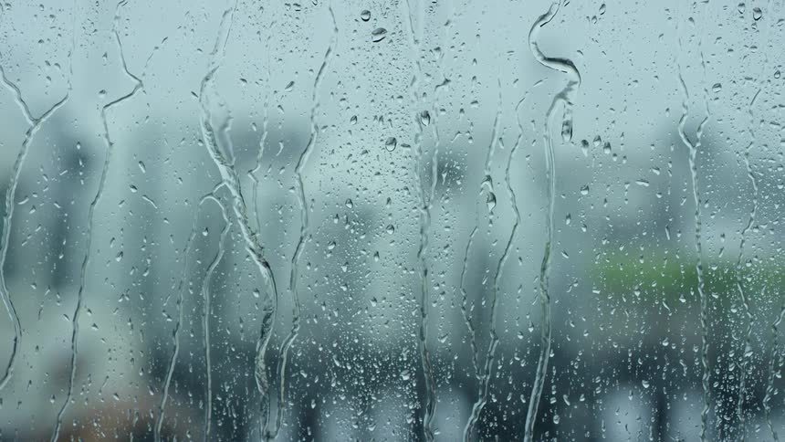 Glass with rain slowly pouring down