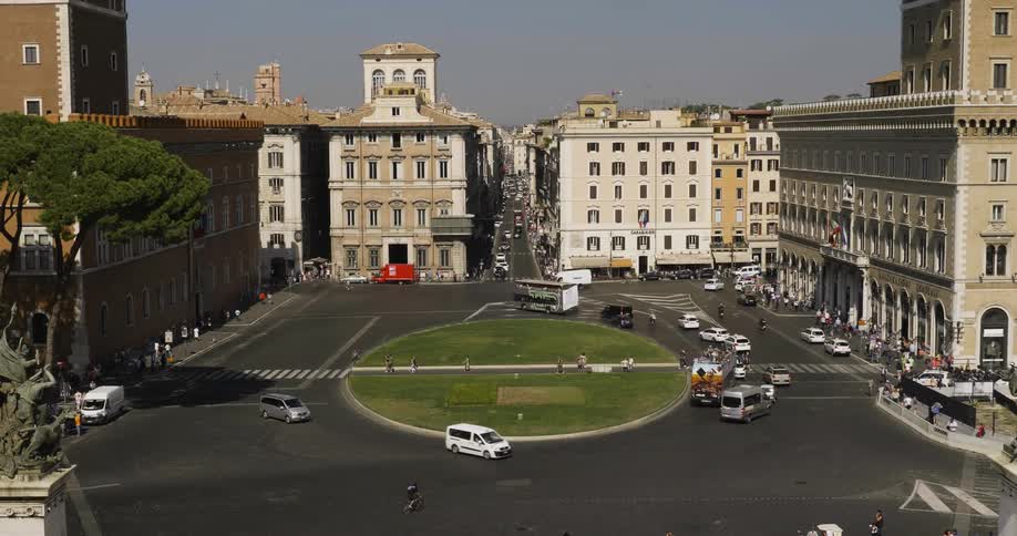 Cars driving in a traffic circle in the middle of a city