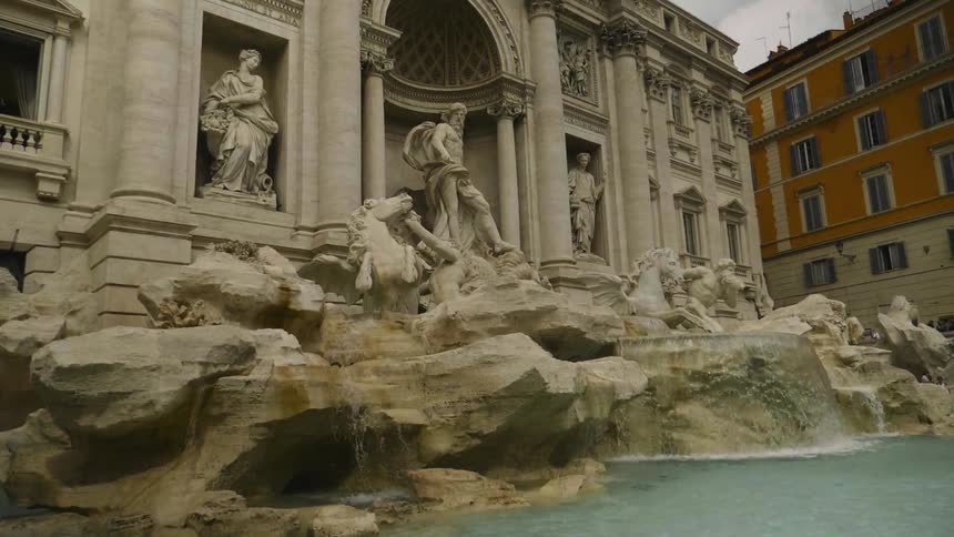 Water falls into a pool near a building