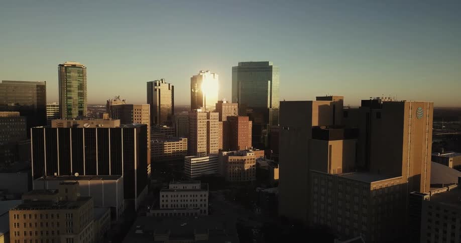 The sun shines on the windows of a skyscraper in a city skyline
