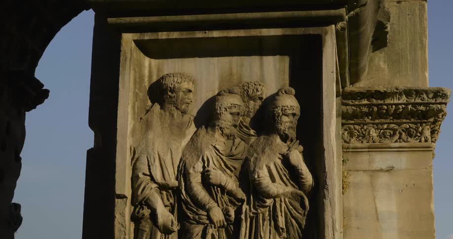 A shadow darkens part of a roman frieze on an ancient ruin