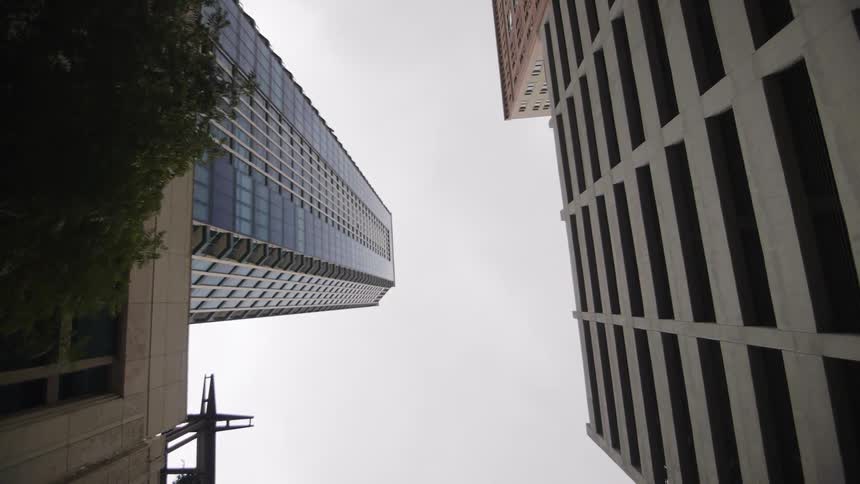 High rises in a city stretch into an overcast sky
