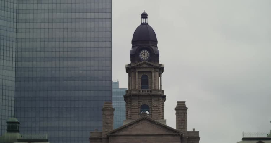 A clock tower stands near a skyscraper
