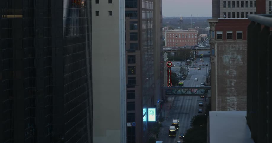 Traffic travels on a city street between skyscrapers