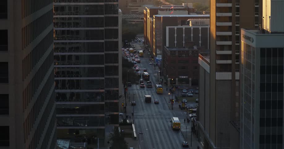 Vehicles traveling down a road in the middle of a city
