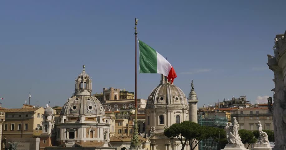 Flag waves in the wind in front of many buildings