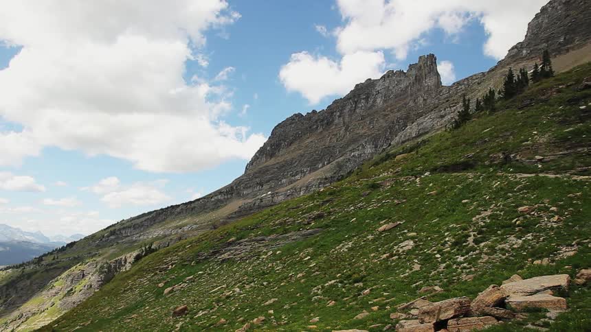 View of clouds soaring over hilly terrain