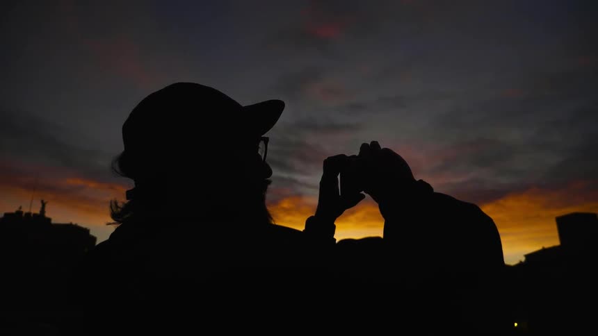 A man is taking photographs at dawn