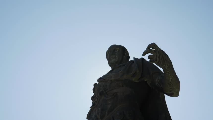 The sun shines on a statue of a man