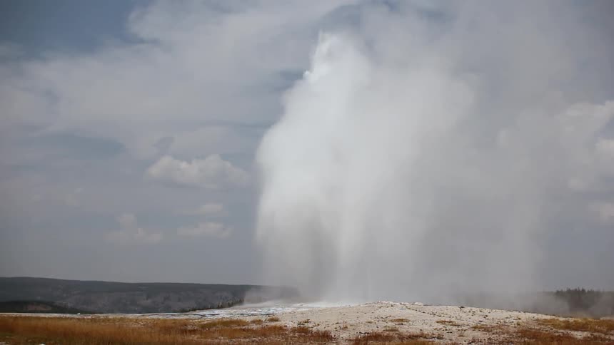 A geyser sprays into the air on a sunny day