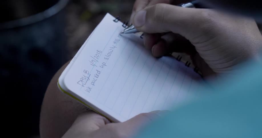 Person writing on a notebook
