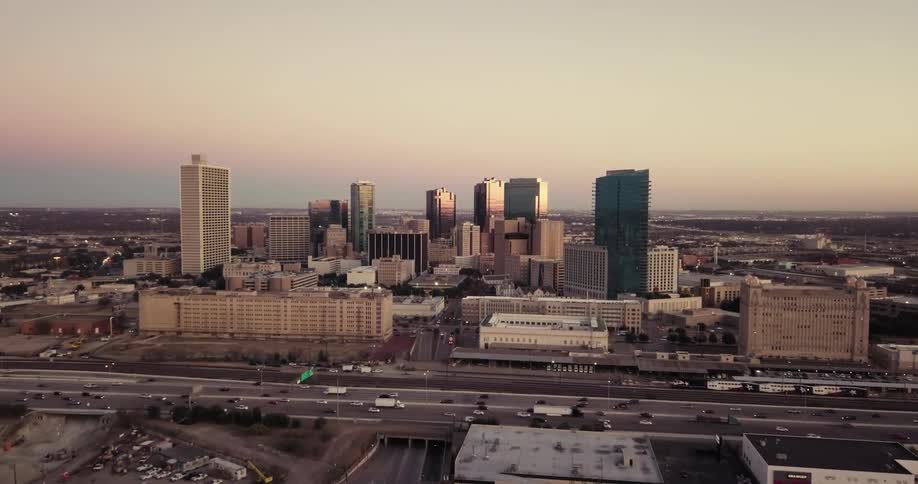 Traffic travels on a highway in front of a city skyline