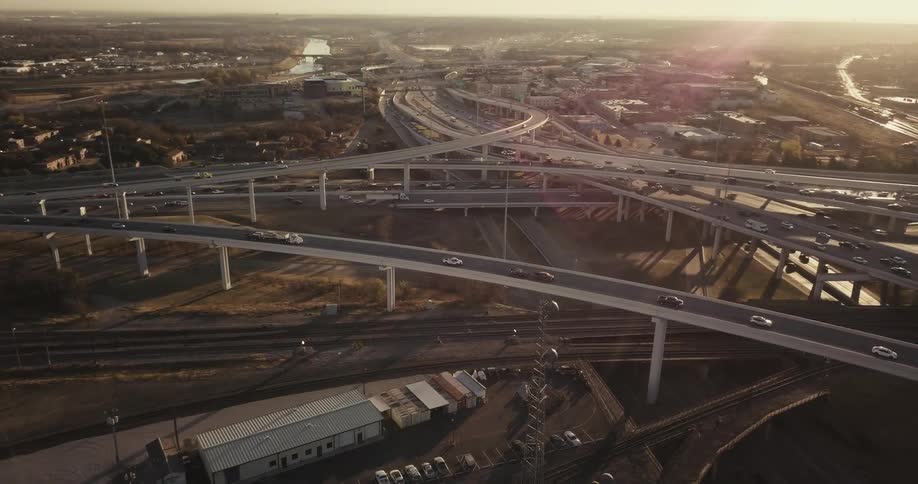 Vehicles travel on a complex freeway system at dusk
