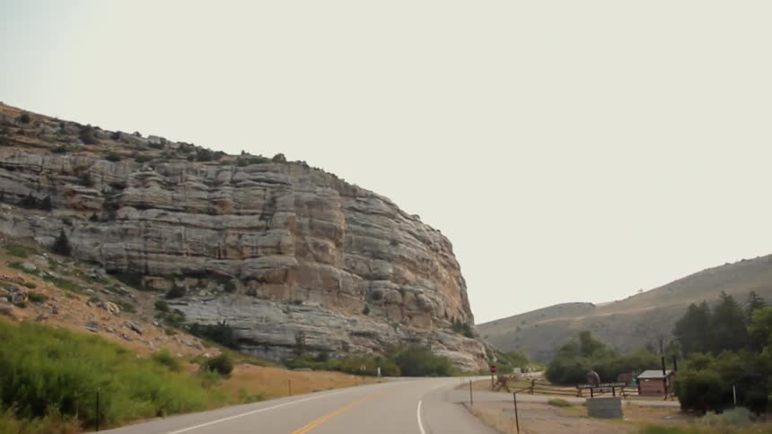 Traveling view going down a country road surrounded by rock formations