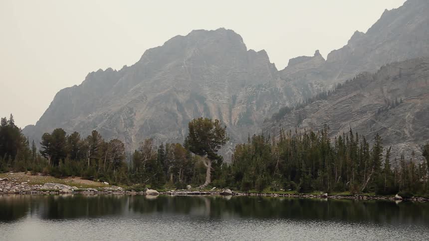 Trees surround a mountain lake and are reflected on its surface