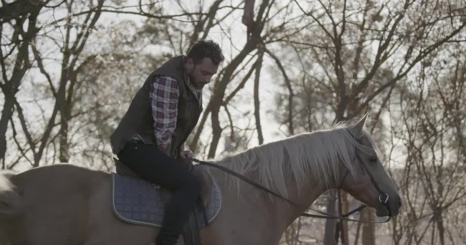 Man gets on horse and gets ready to ride