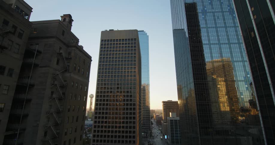 Cars drive by tall city buildings