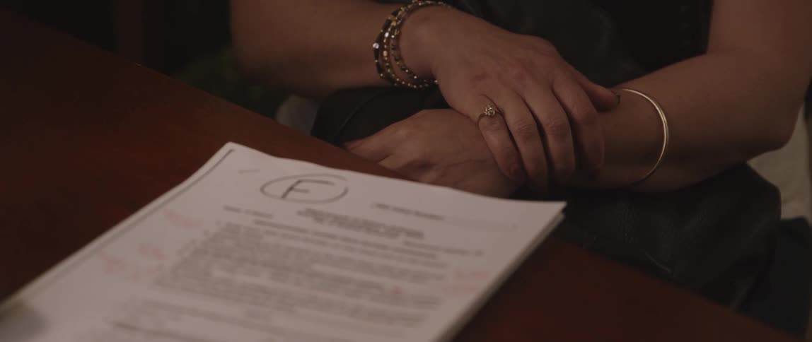 Person's hands and a paper on a table