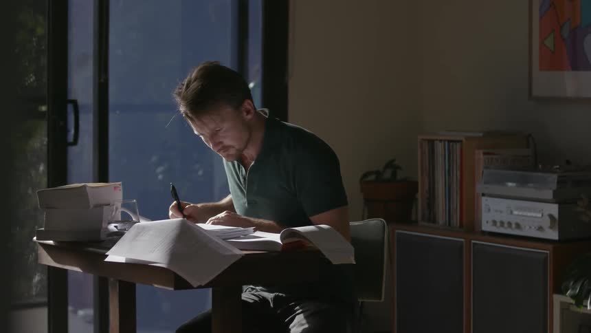 Man sitting at desk in home office reading