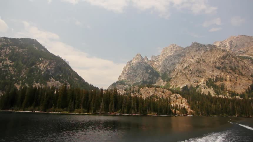 Traveling view going down a river with mountains in the background