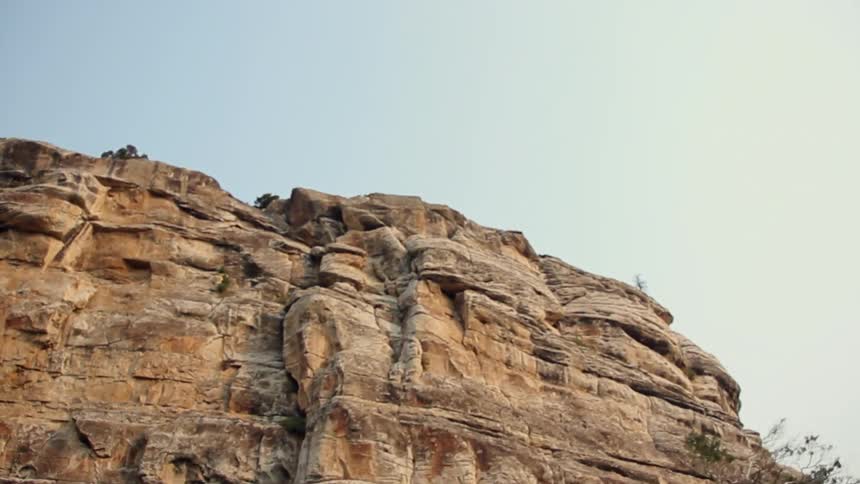 Sparse bushes cling to bare cliff tops