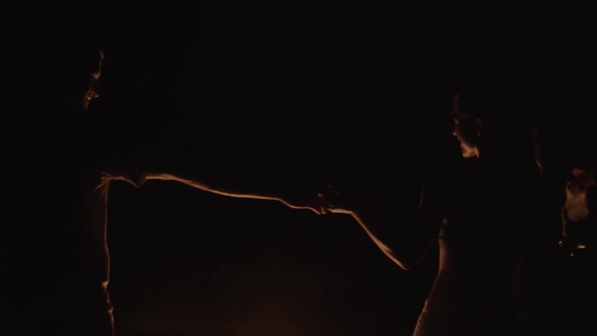 Silhouette of a two people dancing at night