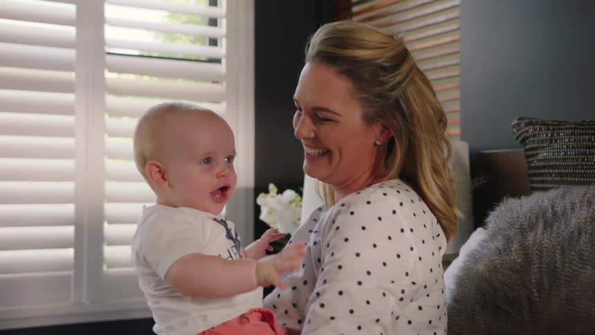 Woman holding a baby in bed