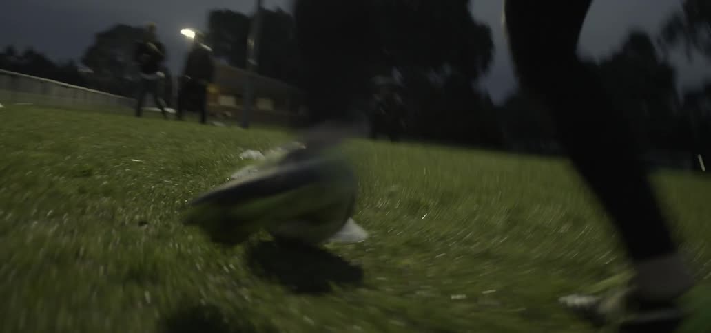 Person kicking a soccer ball at night
