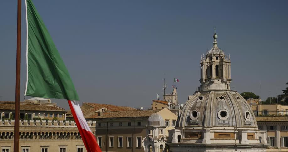 Flag waving in the wind in front of city buildings