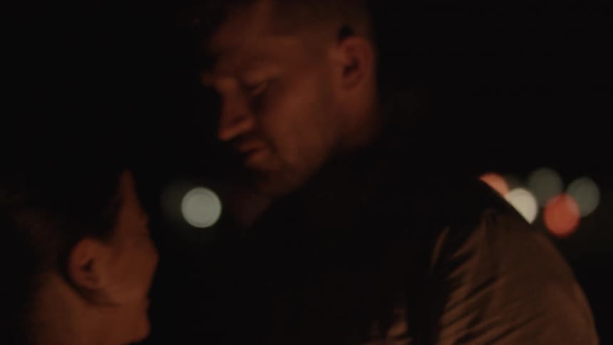 A man and woman dance next to a bonfire at night