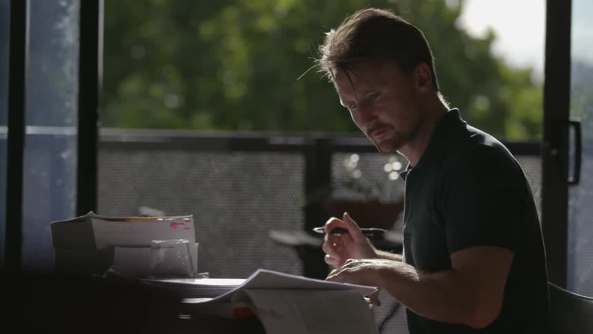 Man writing on a piece of paper at a desk