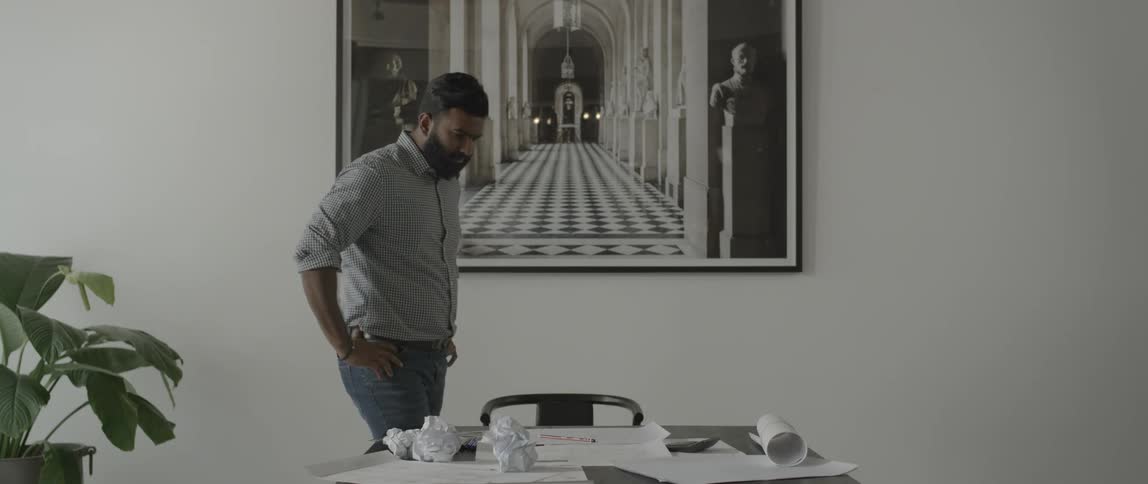 A man looks down at a blank piece of paper