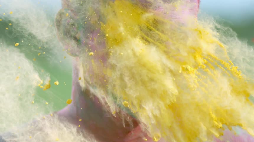 A man gets colored dirt thrown in his face
