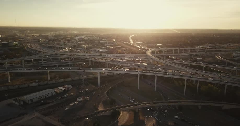 Traffic travels on a highway at sunset
