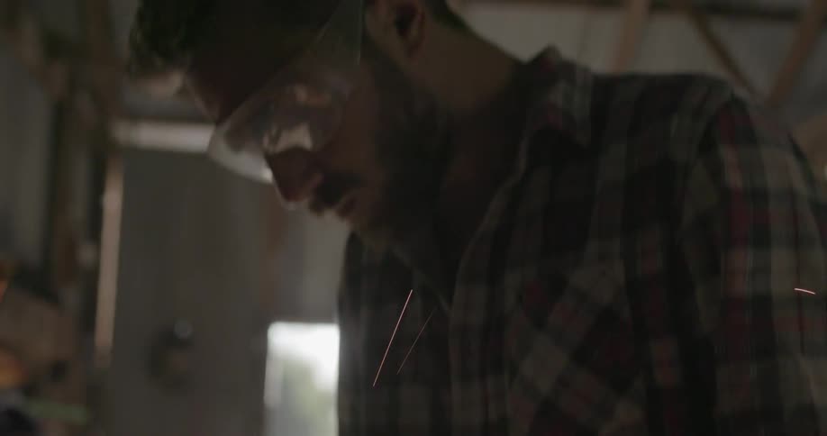 A man uses a saw on a metal pipe