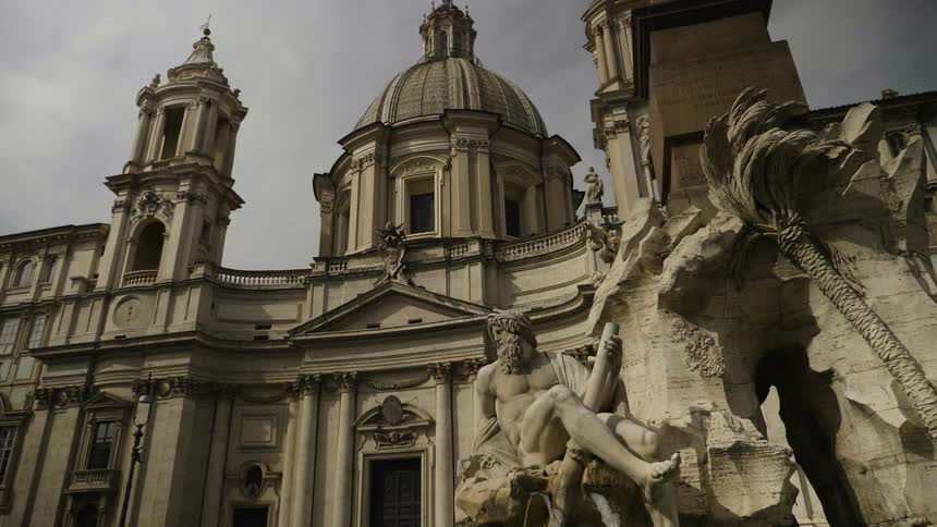A statue in front of a domed stone building