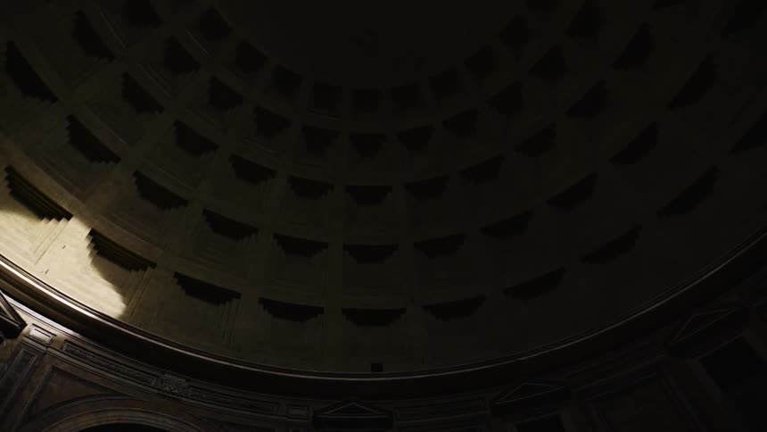 The sun shines on the interior stone work of a dome