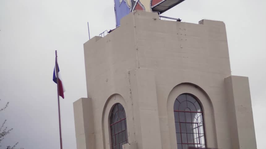 A stone building with a billboard on top