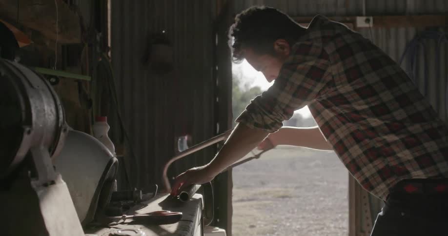 A man saws a metal pipe