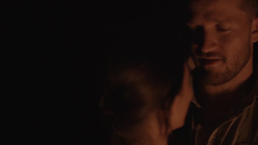 Man and woman talking in the firelight at night
