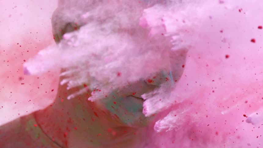 Colorful powder flies all around a man's face