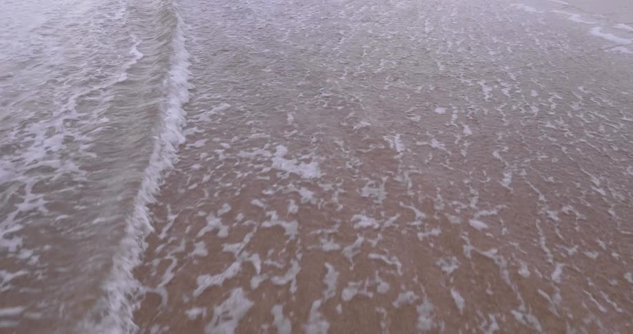 Water splashing to a sandy shore