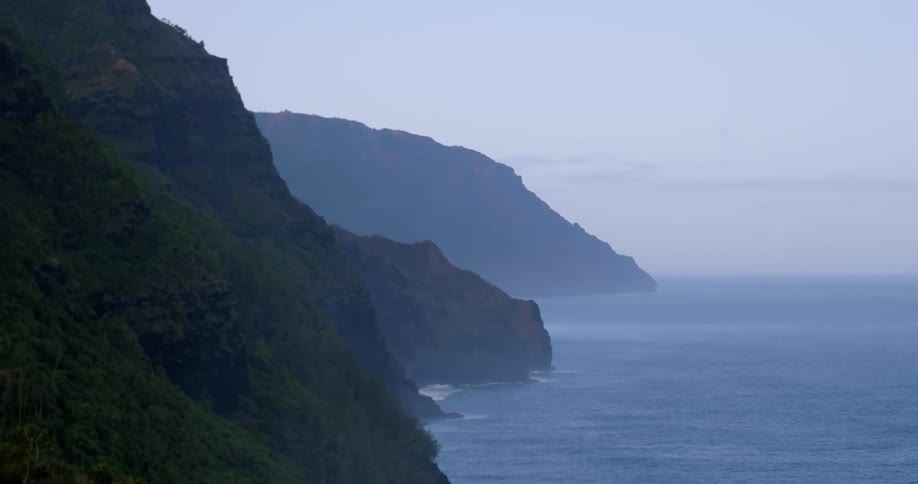 Ocean waves splashing up to a hilly shore